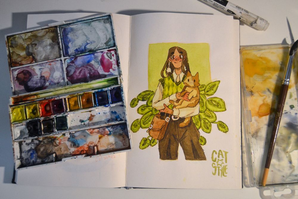 Picture of a watercolor painting representing a girl with brown hair, a green knit sweater and holding a cat in her arms with plants in thr background