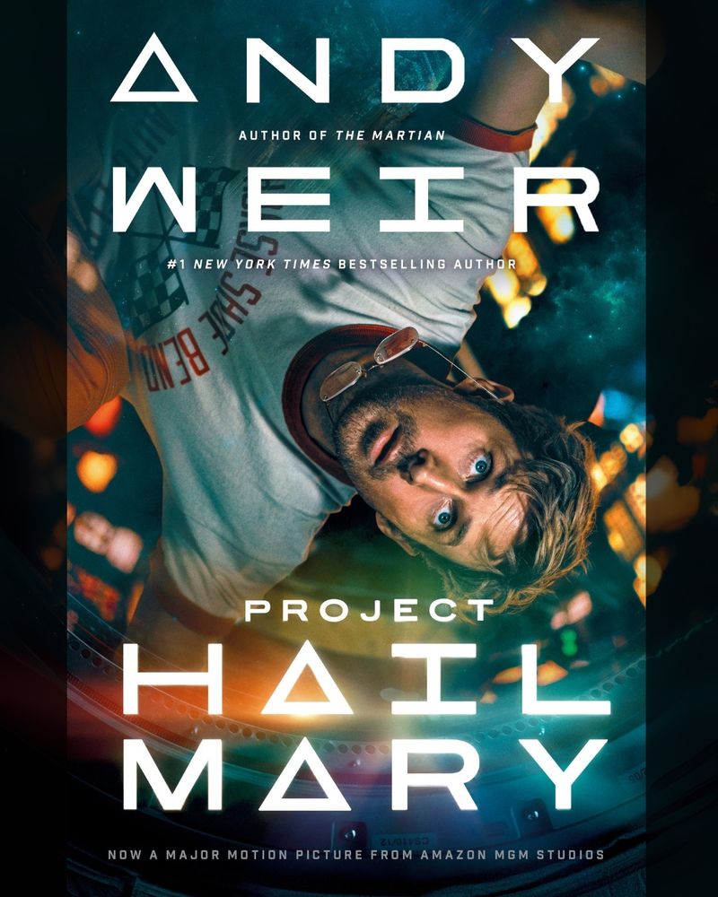 Book cover depicts Ryan Gosling floating upside down in zero g in a space craft. He is wearing a t-shirt and his glasses are floating off his face.

Text reads:

ANDY WEIR
Author of The Martian
#1 New Your Times Bestselling Author

PROJECT
HAIL
MARY

NOW A MAJOR MOTION PICTURE FROM AMAZON MGM STUDIOS
