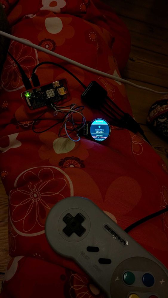 A Raspberry Pi Zero W connected to a Pimoroni LCD screen displaying baby activity tracker data. A gamepad-style controller is used to log events like sleep and feeding. The LCD screen shows the current or latest sleep and feeding status.