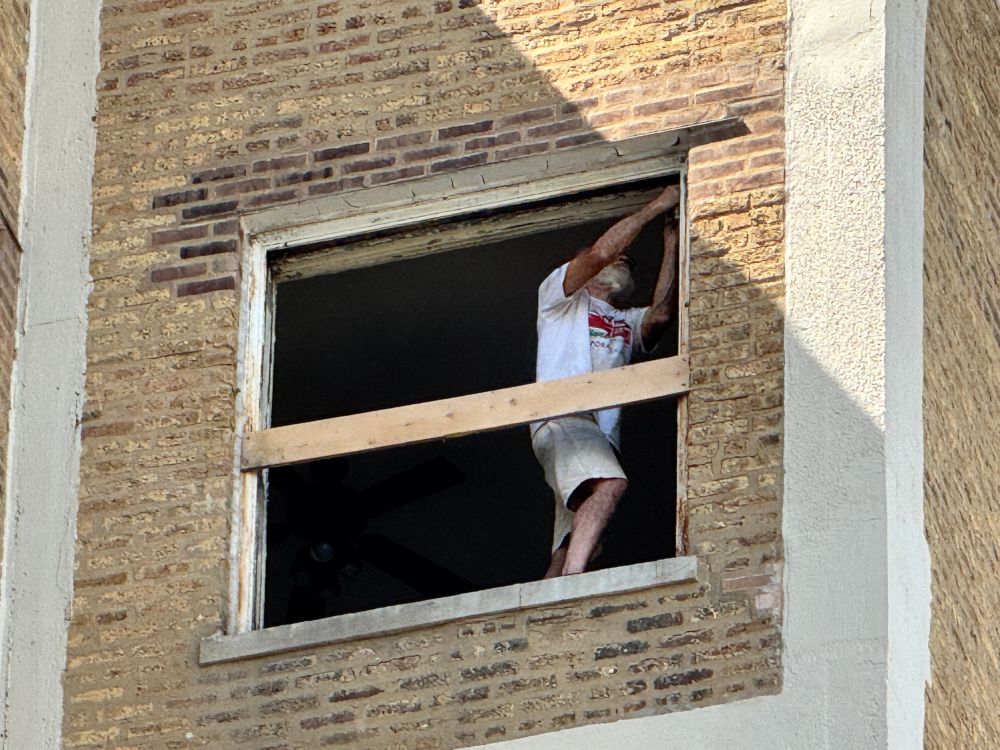 My neighbor installing new windows on the 10th floor of our building