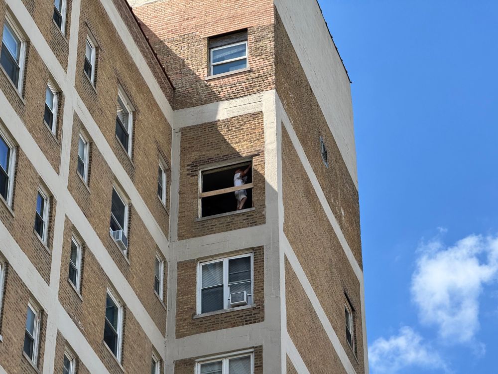 My neighbor installing new windows on the 10th floor of our building