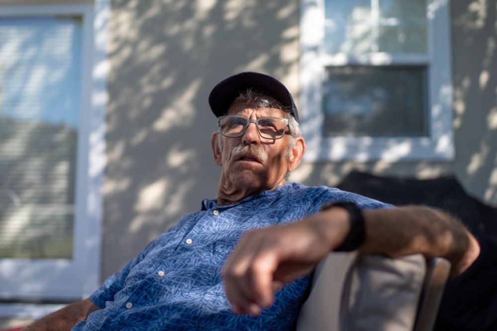 Christy Morrill sitting in his back yard. Morrill has autoimmune encephalitis and was robbed of decades of his memories. 
