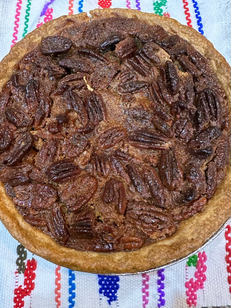 Pecan pie sitting atop a colorful woven cloth
