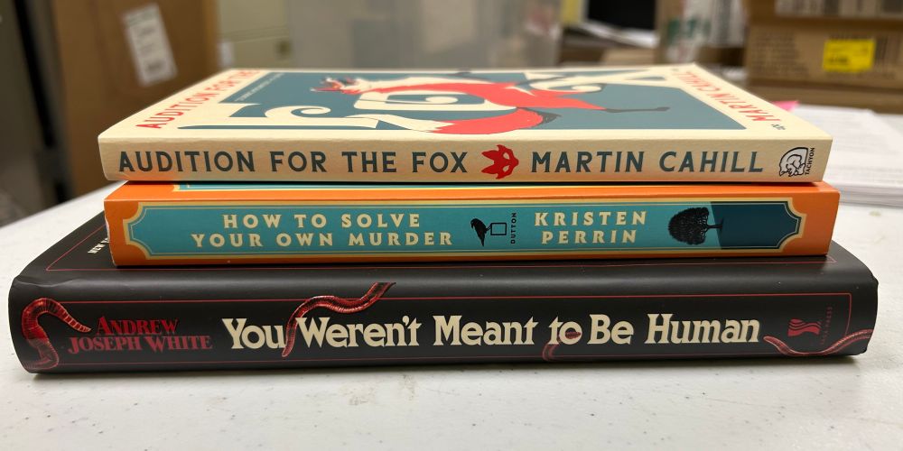 Photo of a small stack of books: You Weren’t Meant to be Humam by Andrew Joseph White, How to Solve Your Own Murder by Kristen Perrin, and Audition for the Fox by Martin Cahill