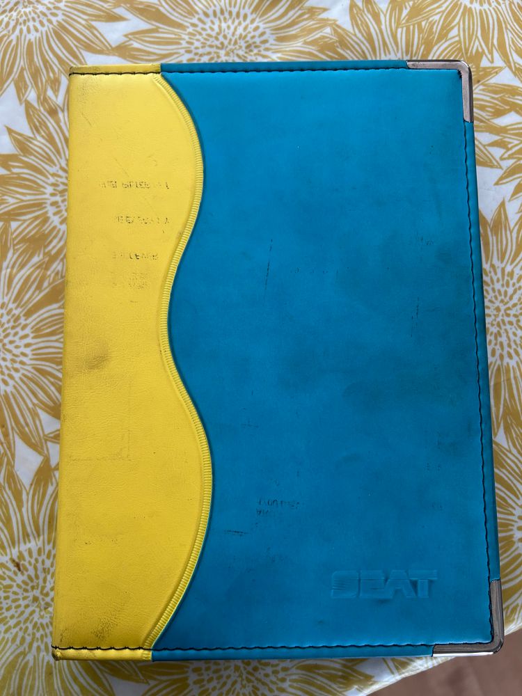 The closed wallet. It’s very Nineties, with a wavy yellow spine and bright blue cover. 