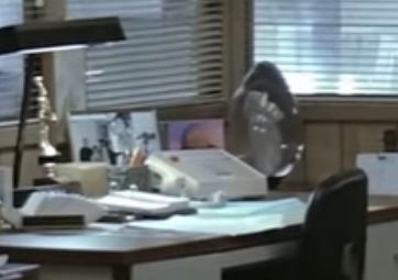 A zoomed in shot of the left side of the previous photo, containing many items on a desk, one of them resembling a photo of Spaceship Earth