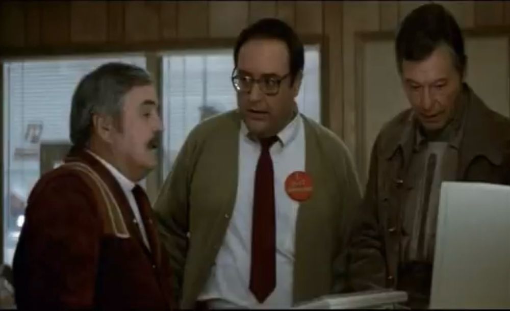 Scotty, a plexiglass scientist and Dr. McCoy looking at a computer from the 1980s