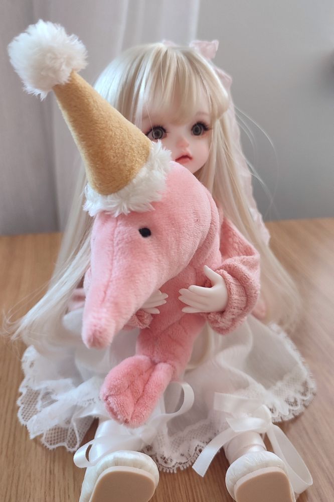 Ball jointed doll holding a shrimp plush 