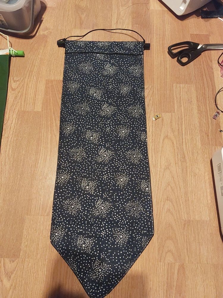 an extra large pin banner with a dark navy back, it is approximately 75cm long. The print is of very tiny silver stars.