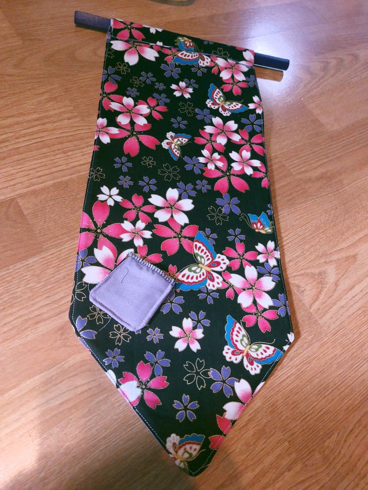 A regular sized pin banner with sakura flowers and butterflies on the backside. It is approximately 55cm long.