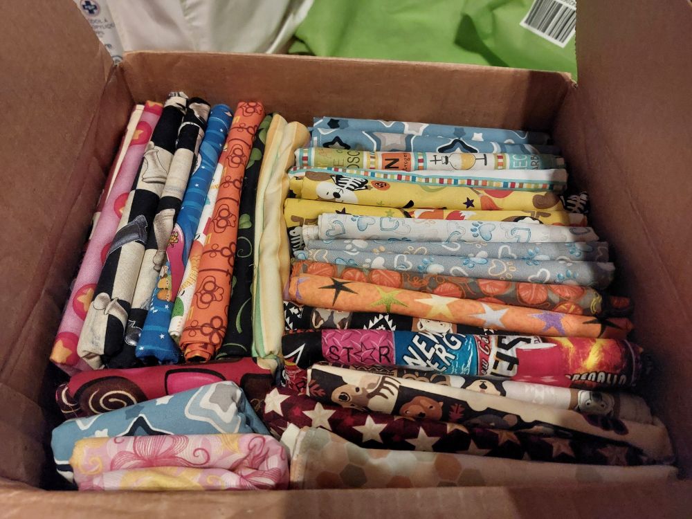 A box filled with bandanas of various colours and patterns 
