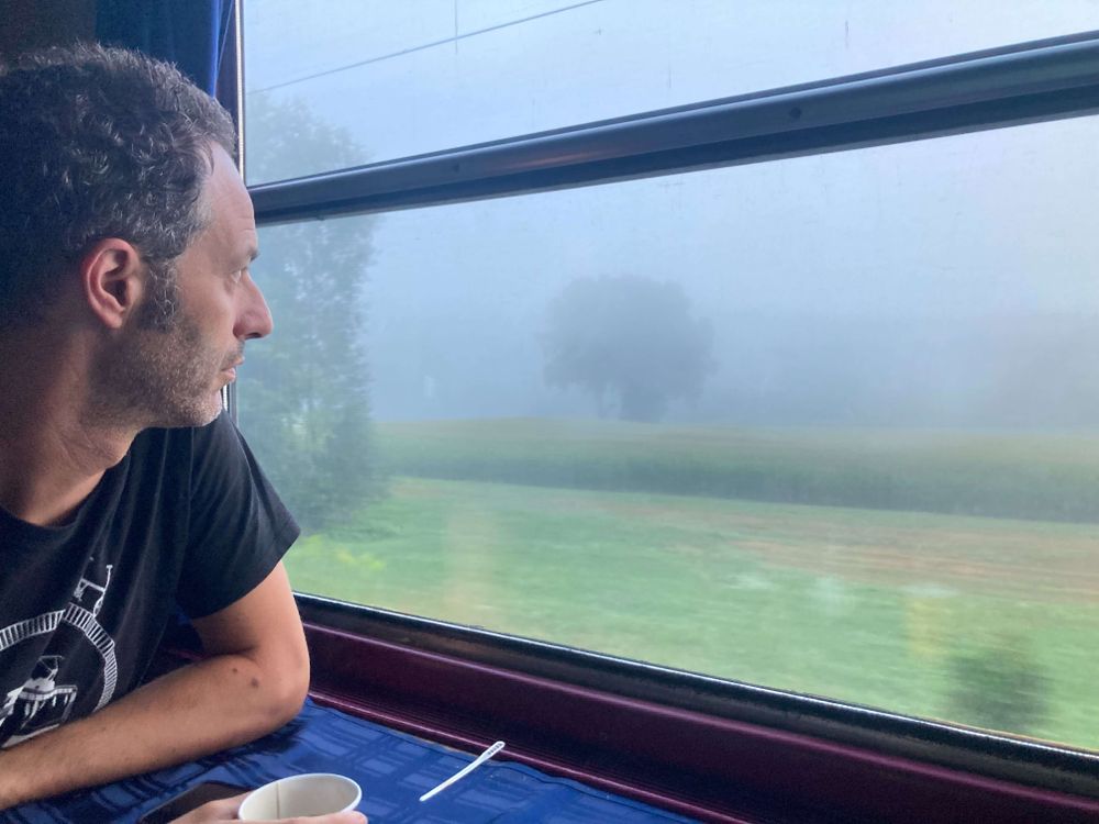 Jon staring out of the window onto a foggy landscape from the dining car on Optima Express