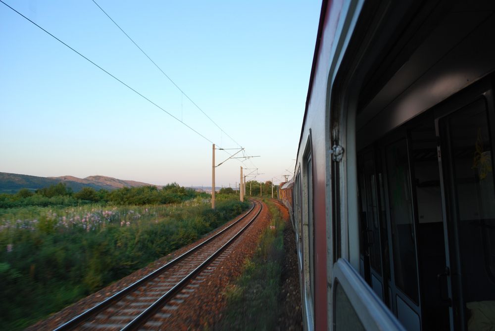 Evening view through the open window of a train