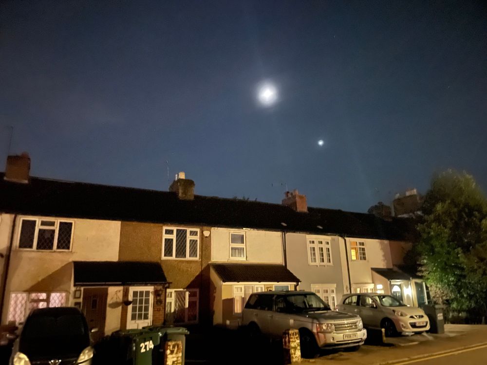 The moon and Venus above a row of terraced houses