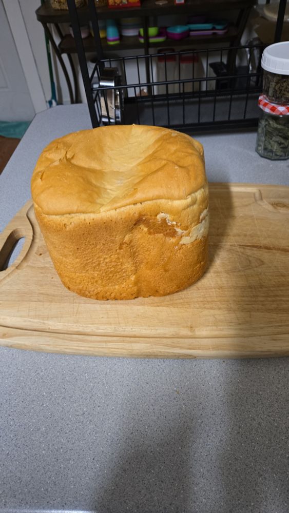 A loaf of homemade bread that has sadly collapsed on top.