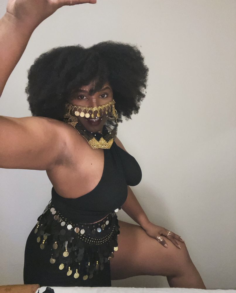 A Black woman in a Black belly dancing costume