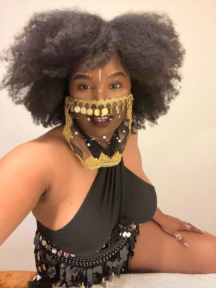 A Black woman in a Black belly dancing costume