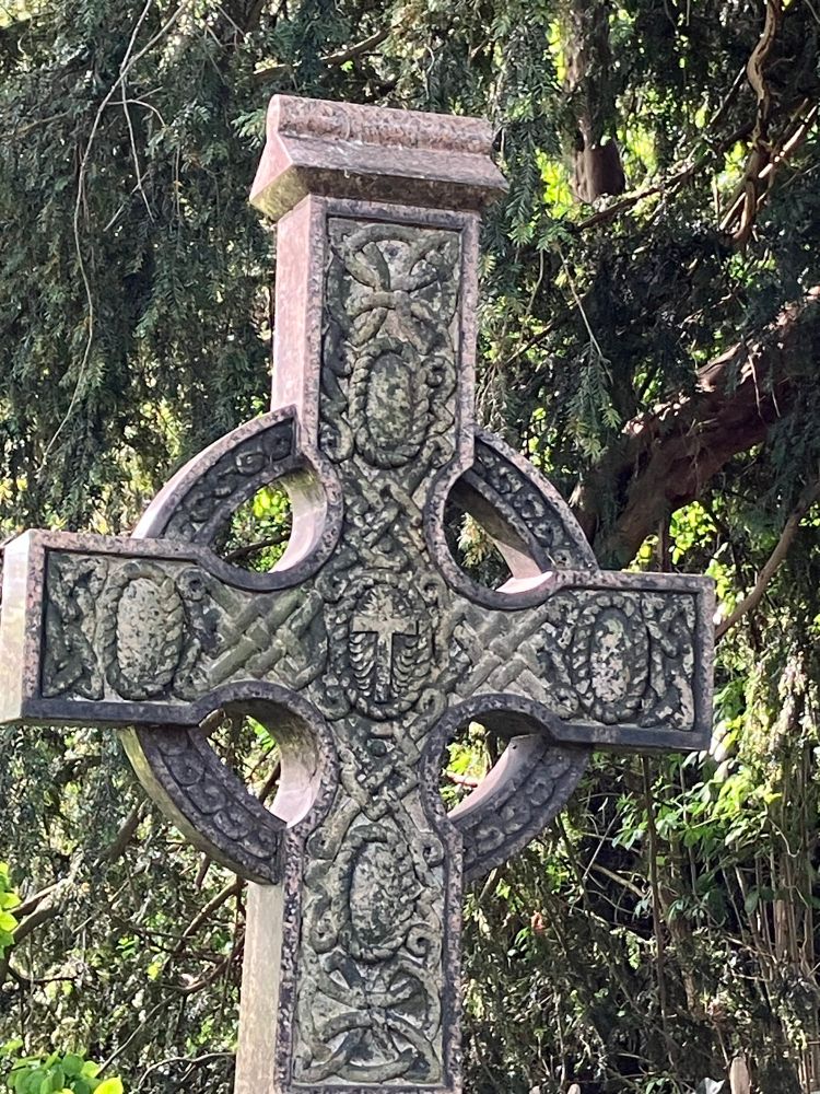 One of the gravestones in St Mary’s church yard - a Celtic style cross design with intricate carving. It stands under a yew tree