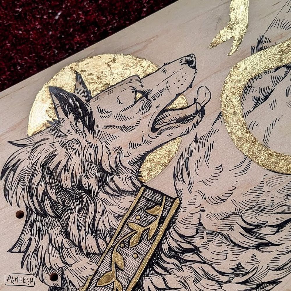 Traditional art. A bare wooden skateboard lies against a dark red background. The board is covered in hand drawn art — black ink and gold foil. It depicts a hound on all fours, crouched or crawling, looking back with a worried expression, mouth open and ears alert. Around it coins a golden snake, nose to nose with the dog. The snake, the disk behind the dog's head, and the eye, are highlighted in gold foil. 