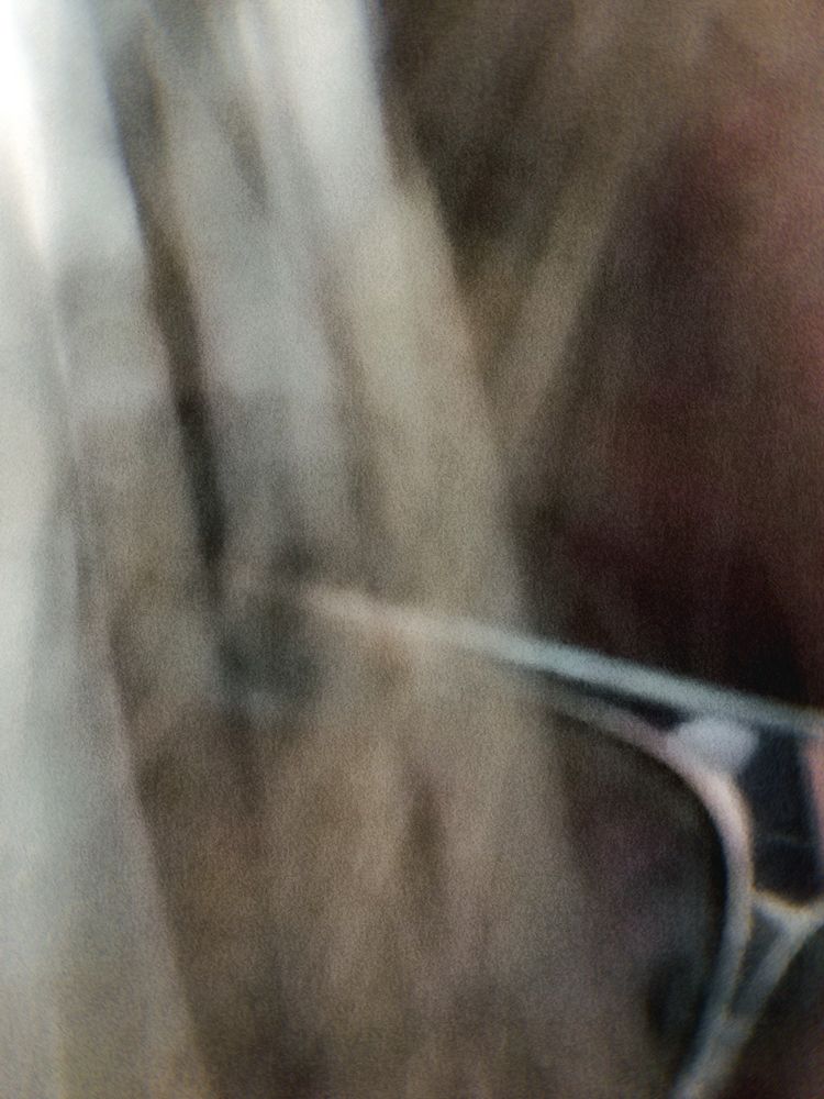 Extreme close-up of an eye wearing glasses shrouded by hair 