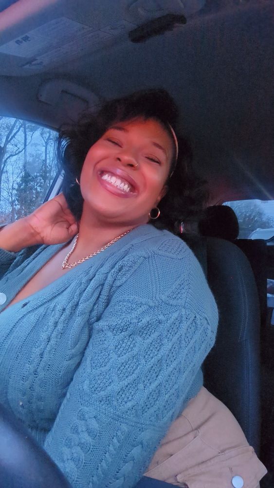 Pretty Black woman smiling in her car