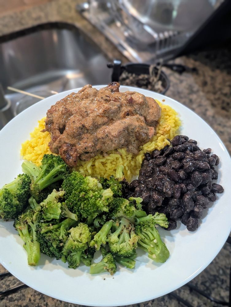 Chicken in a creamy tomato sauce, yellow rice, sauteed broccoli, and black beans