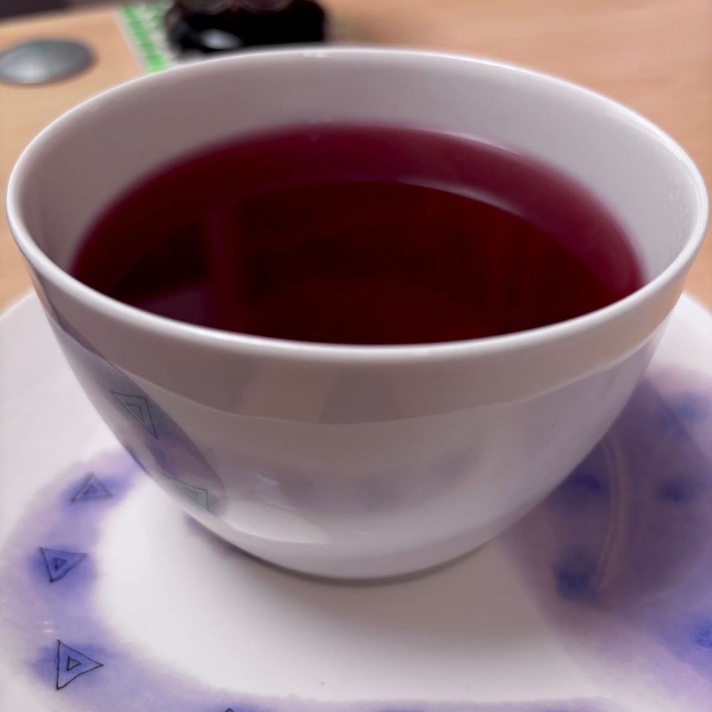 Image of a cup of tea, the tea is a deep red-purple colour, with no milk