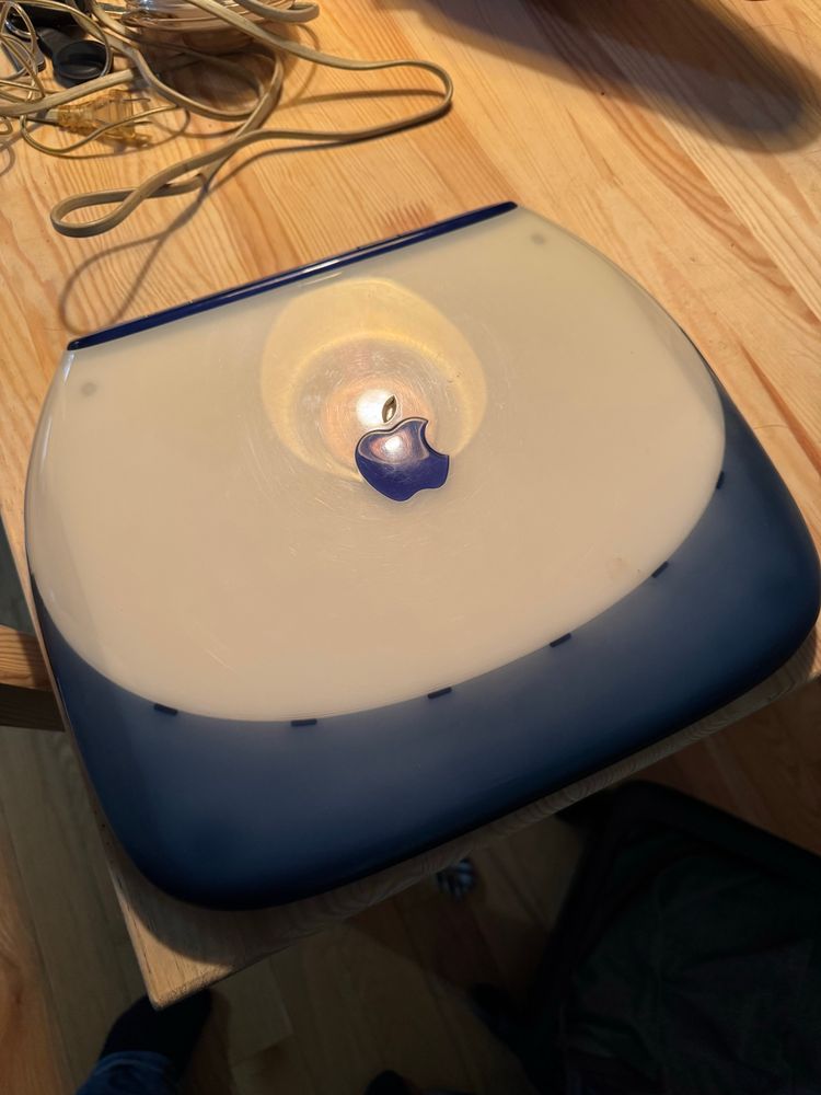 A blueberry clamshell iBook G3 on a kitchen table. 