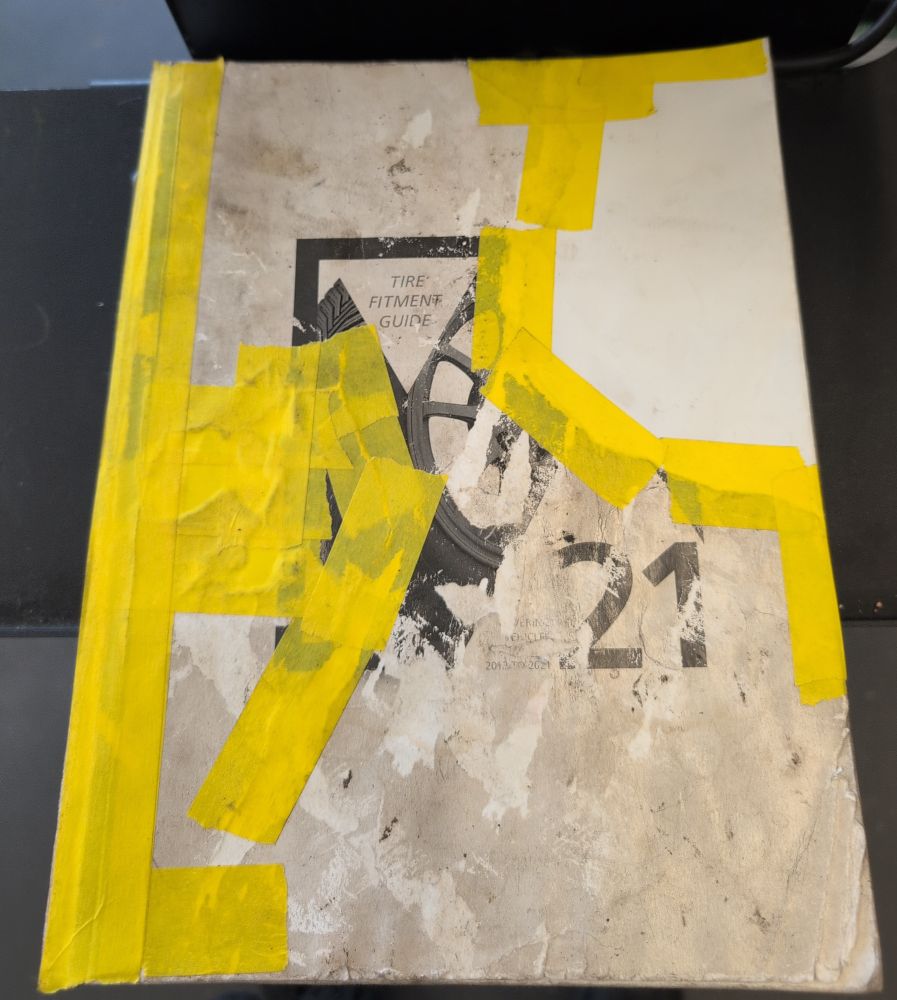 A book cover that was repaired, poorly, with masking tape