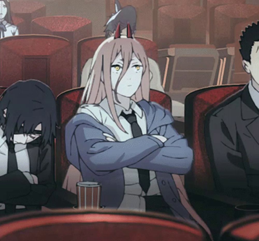 a group of people are sitting in a room with their arms crossed and one of them has horns on her head