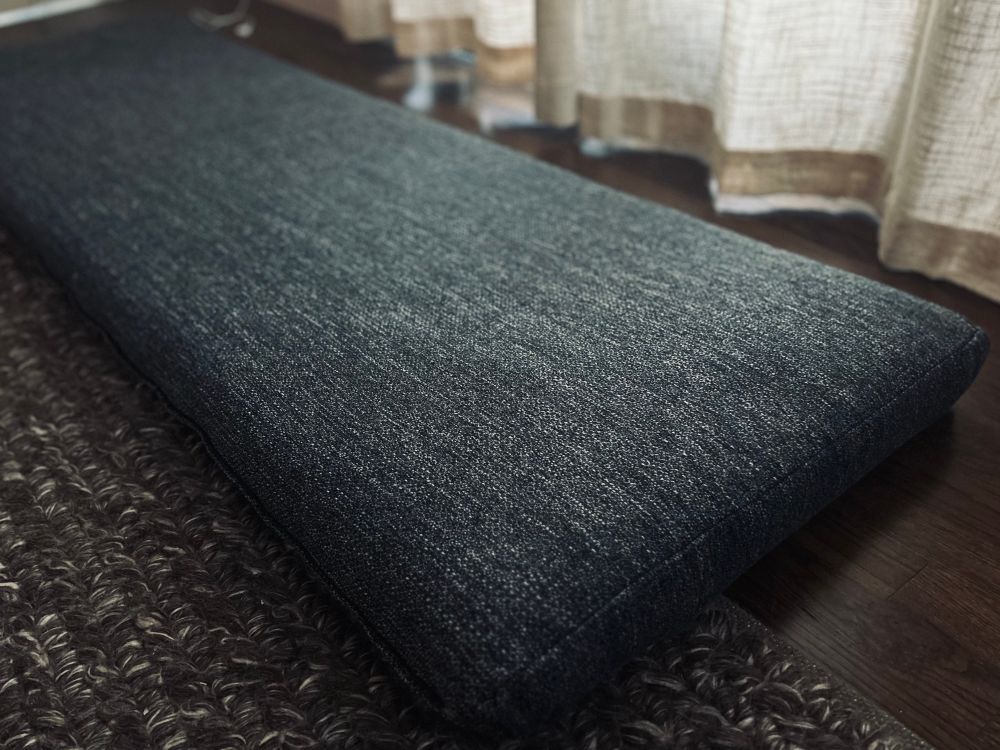 A sturdy denim looking (but soft) fabric cushion, long and plush with nice straight seams.