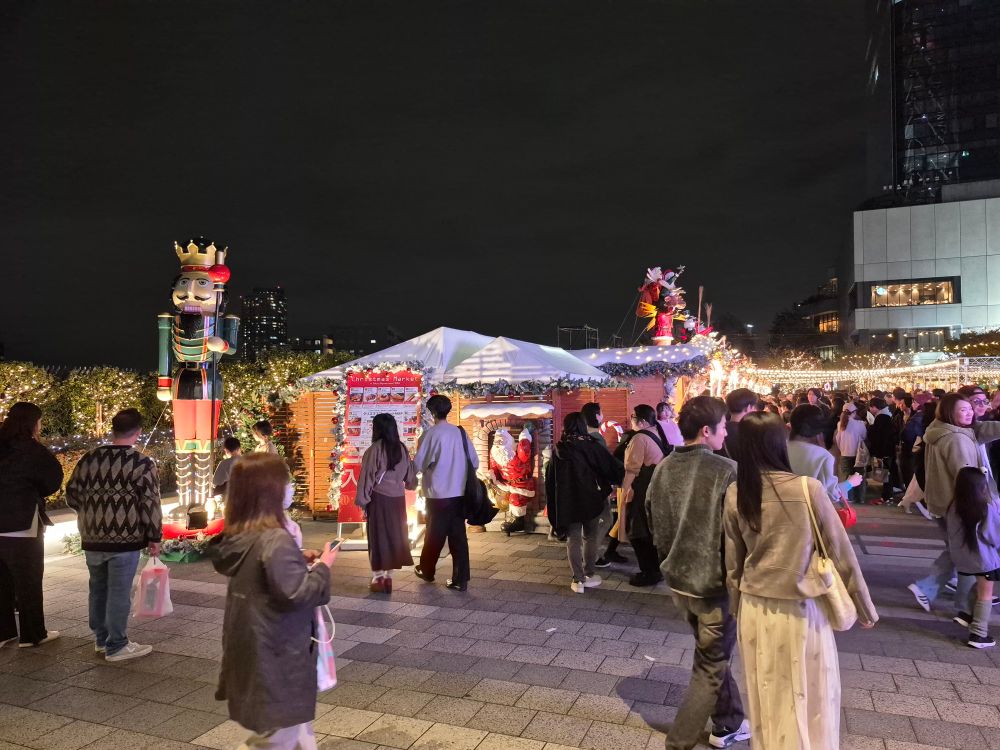 Gelände des Weihnachtsmarktes mit Buden und vielen Besuchern.