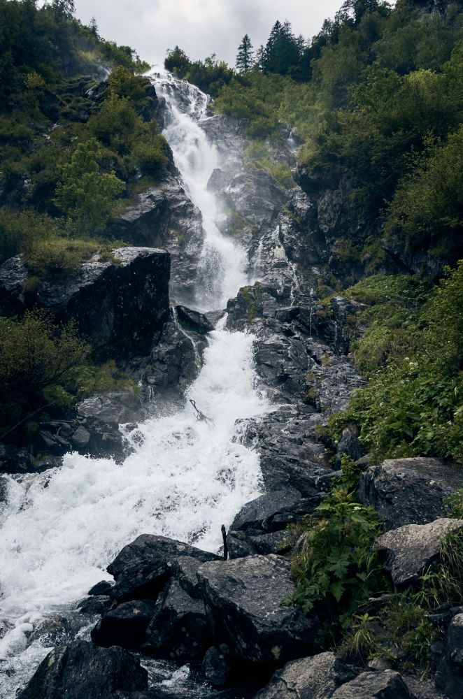 A waterfall rushing down a cliff in the mountains of Austria.