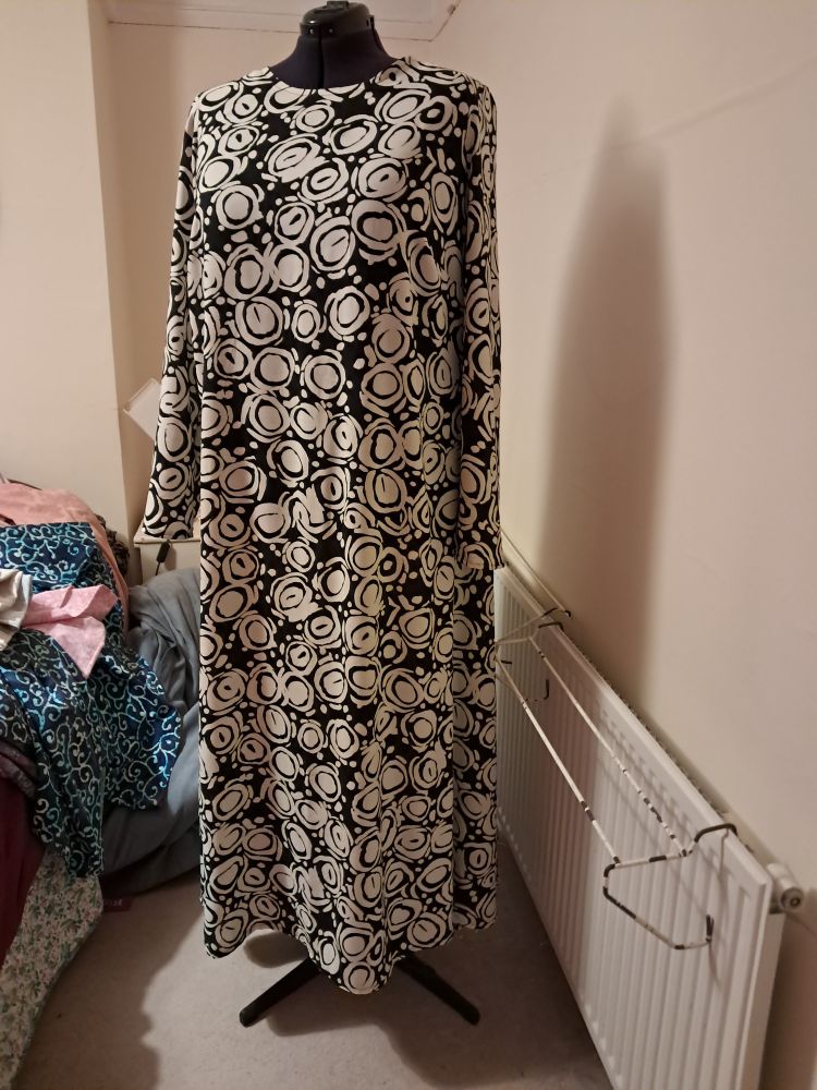 A black & cream long sleaved, ankle length work dress. 