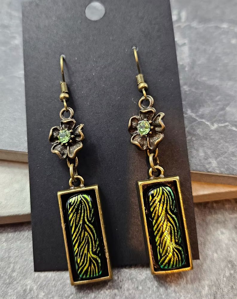 golden green dichroic glass earrings with flower charms on brass colored hooks 