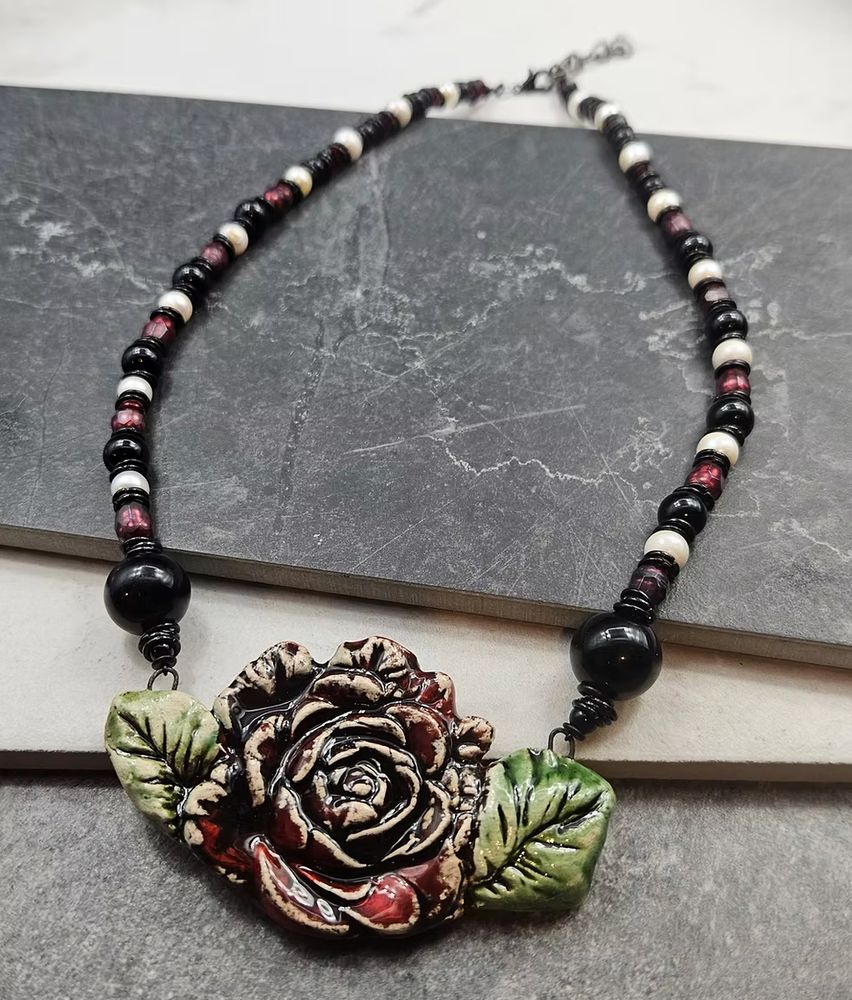 A black white and red beaded necklace with a large red rose Parisian ceramic focal. 