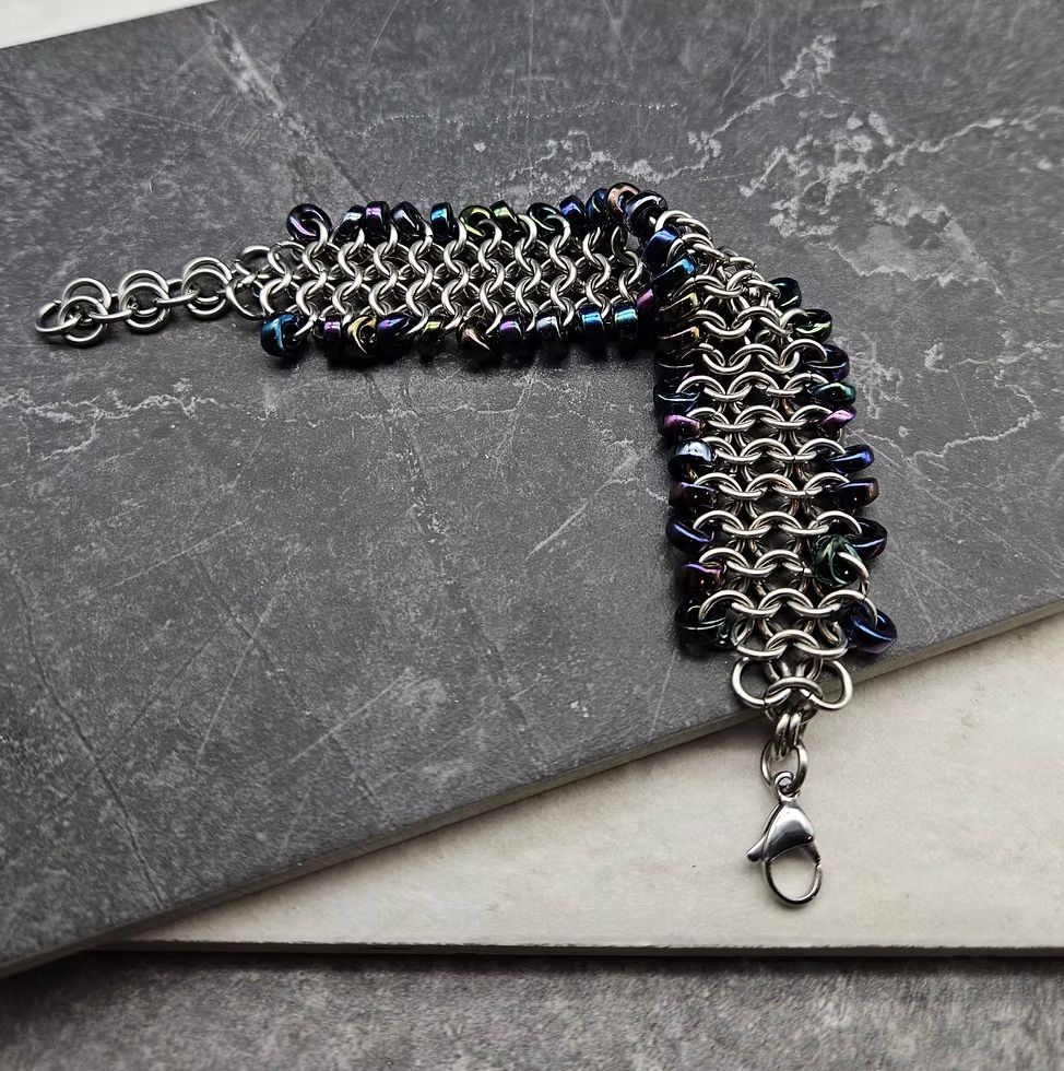 A silver and midnight rainbow chainmail bracelet. 