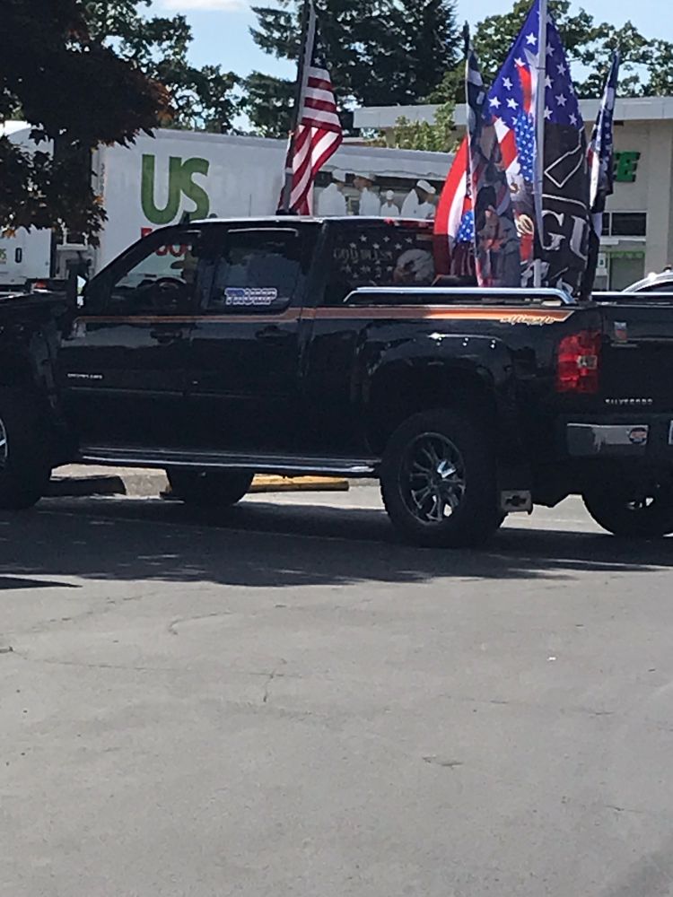 A handful of Trump supporters parked at Oak Grove Fred Meyer, in Milwaukie OR- the usual spot for Friday pro-Democracy street action by Indivisible Clackamas. This pickup is flying several American flags, and one emblazoned with “God, Guns and Trump”.