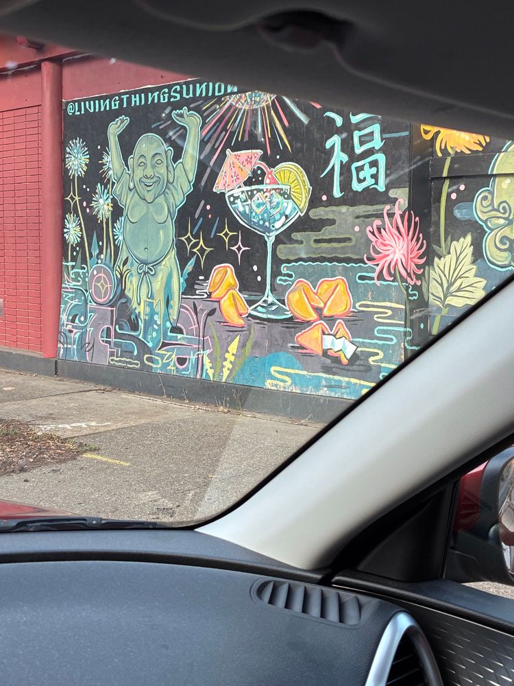 A section of a mural in Portland’s Jade District, at the former site of the Canton Grill restaurant: dancing Buddha, a cocktail with an umbrella & a citrus slice; fortune cookies, chrysanthemums, and I think a groovy disco ball. 