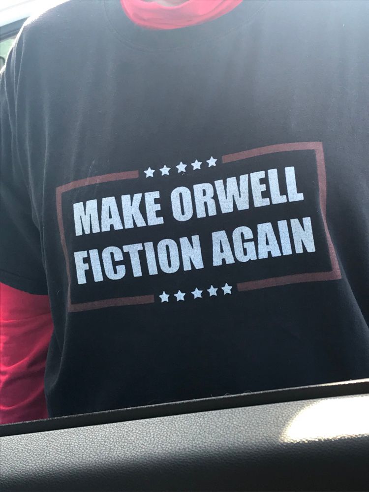 Black tshirt worn by a pro-Democracy activist at a Friday street action in Milwaukie,Oregon. Shirt reads, “Make Orwell Fiction Again”. 