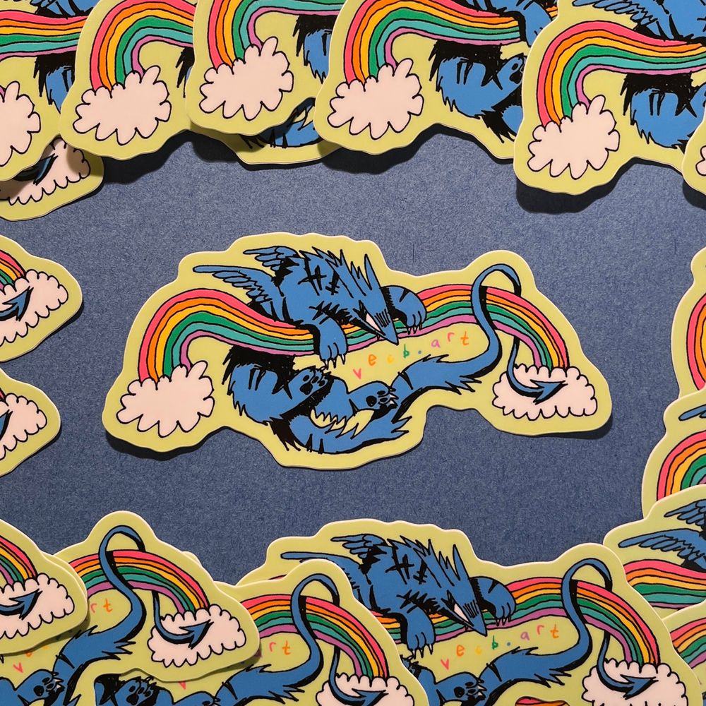 A sticker depicting a blue canine creature with wings and a long tail ending in an arrow shape. The creature is hanging on to a rainbow, which bends under the weight of the creature. Small, colorful handwriting in the negative space reads “vecb.art”
