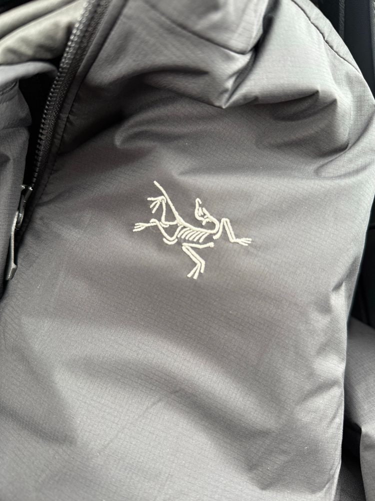 White embroidered Archaeopteryx fossil on a black jacket 