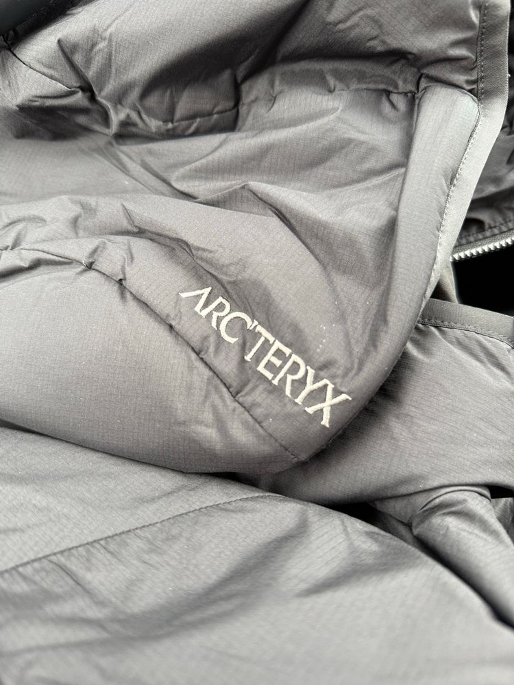 White embroidered “Arc’teryx” brand name on a black jacket 