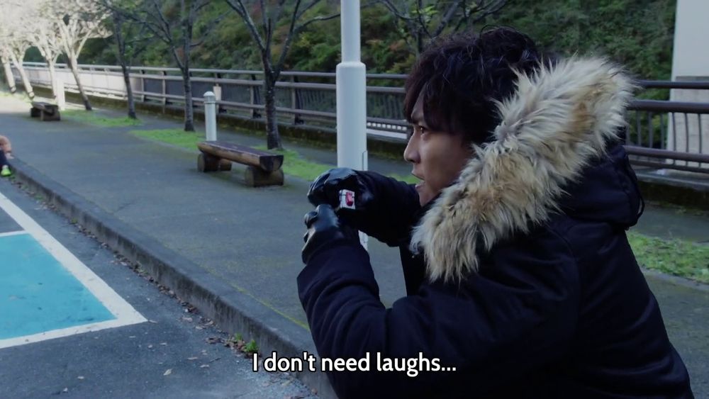 Screen cap of Isamu Fuwa from Kamen Rider Zero-One Episode 14, while holding the Assault Wolf Progrise Key and stating that he doesn't need laughs.