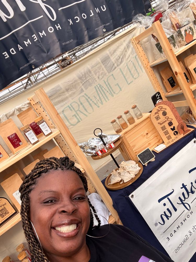 The seasoning fairy in front of her market display 