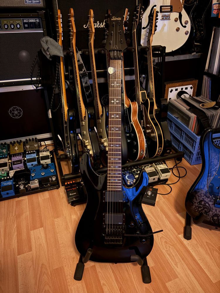 Pic of my Schecter Guitar in front of some Amps, Guitars and Pedalboards