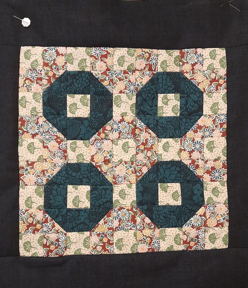 Block of patchwork.  Octogons of navy with a cream/ red contrast.  