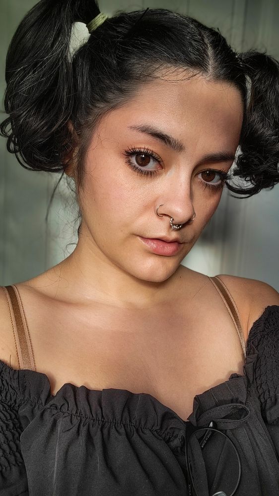me taking photos in front of my window, wearing pigtails 