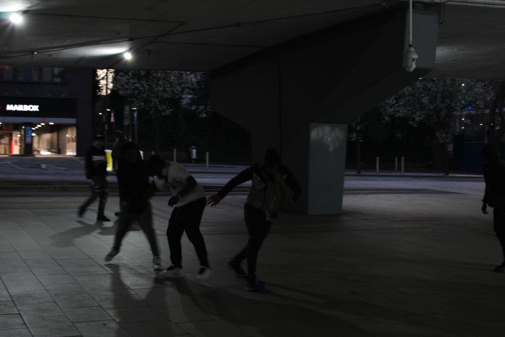 A group of lads play in a dimly lit underpass 