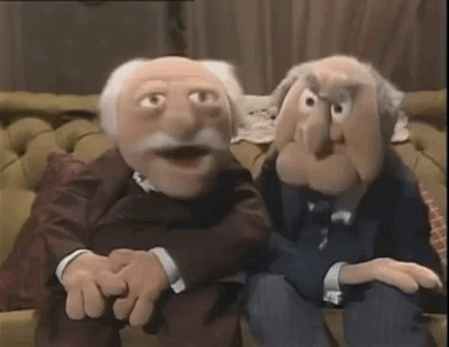 two muppets are sitting next to each other on a couch in a living room .